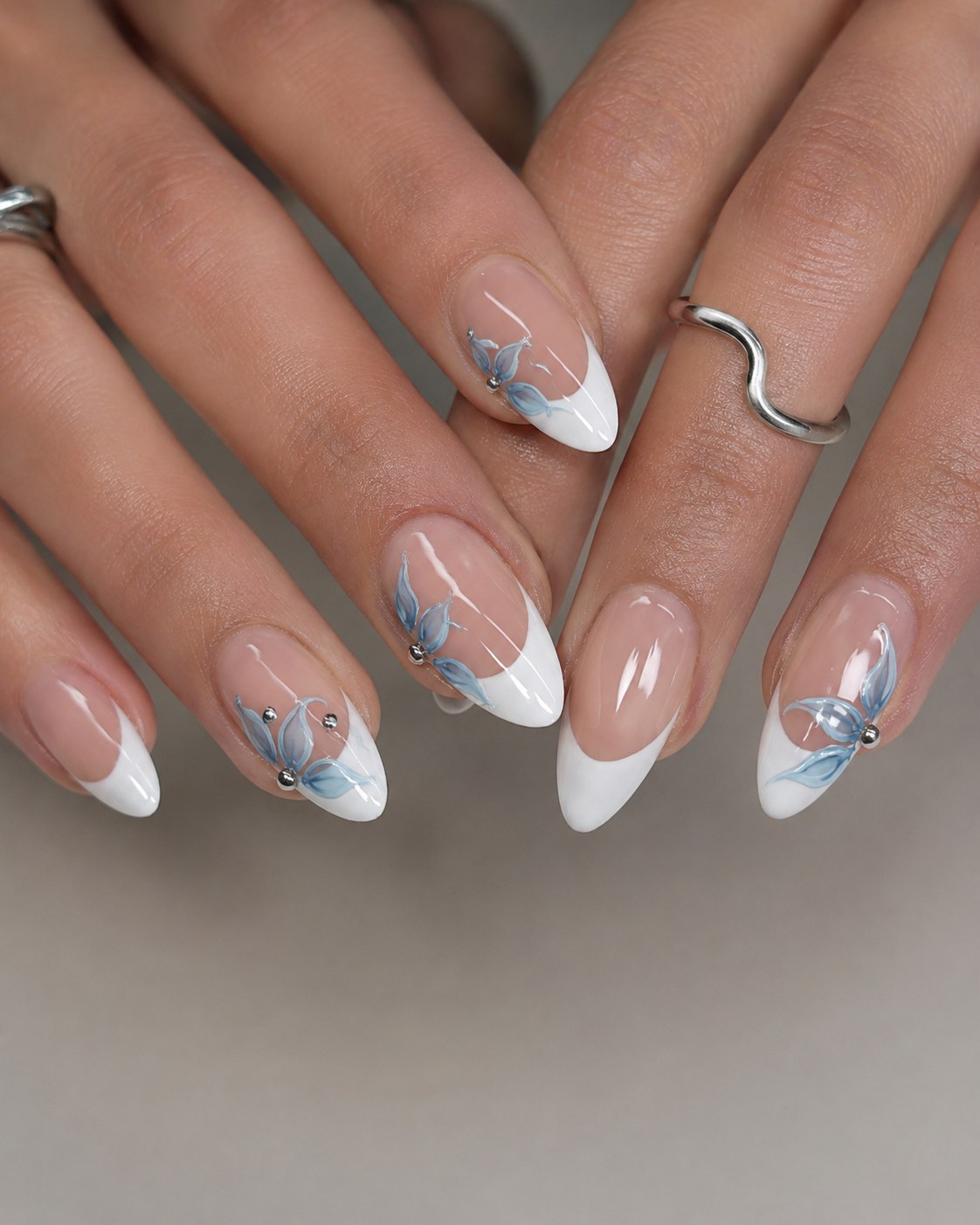 Almond nail ideas summer French tips with soft blue floral line art and rhinestones