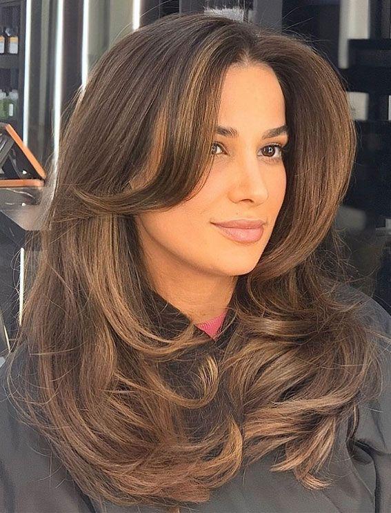 Dark brunette layered blowout haircut with full volume