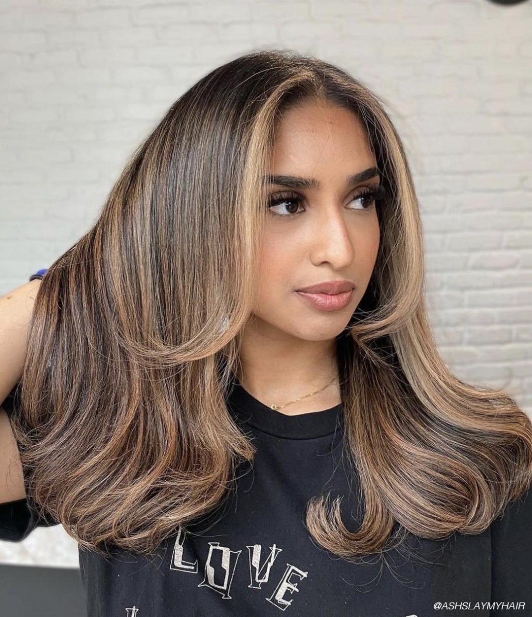Classic brunette layered blowout haircut with soft waves