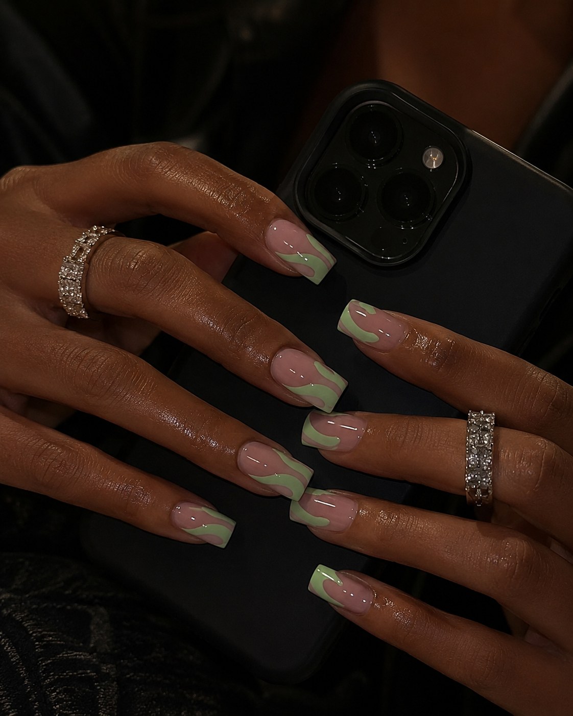 Soft sage green flame-tip nail art over a nude base on long squared nails.