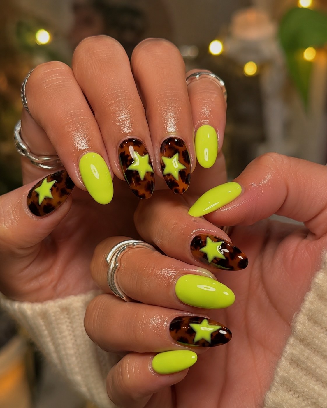 Neon lime green nails paired with tortoiseshell print accents, a bold pick for neon nails for dark skin.