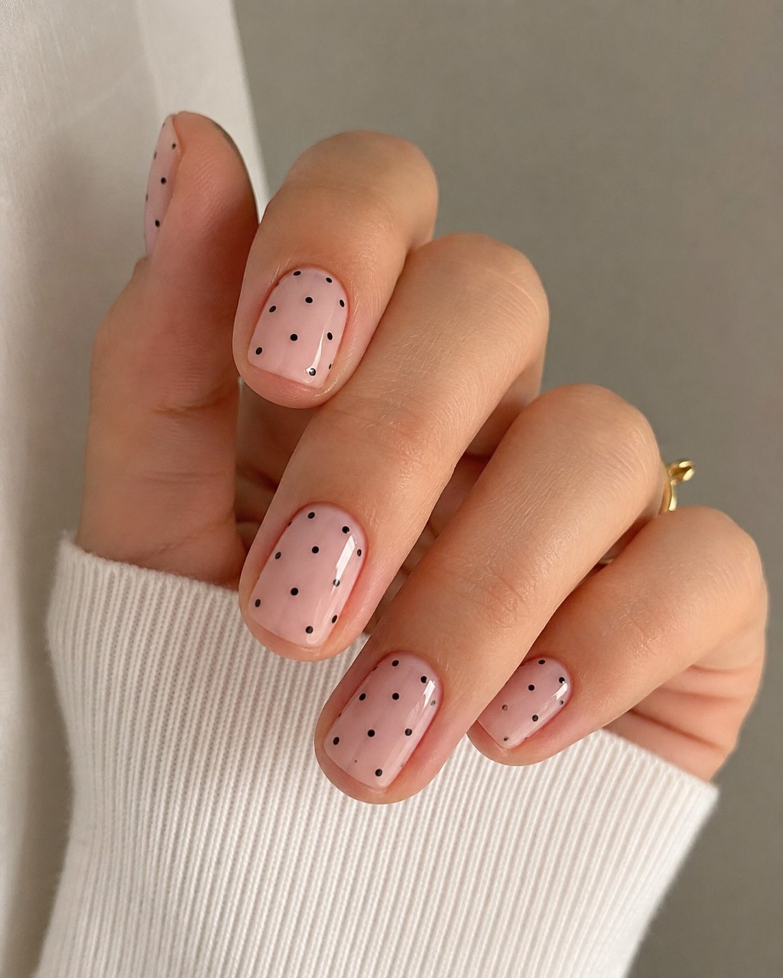 Short nude polka dot nail art with classic black dots on squoval nails