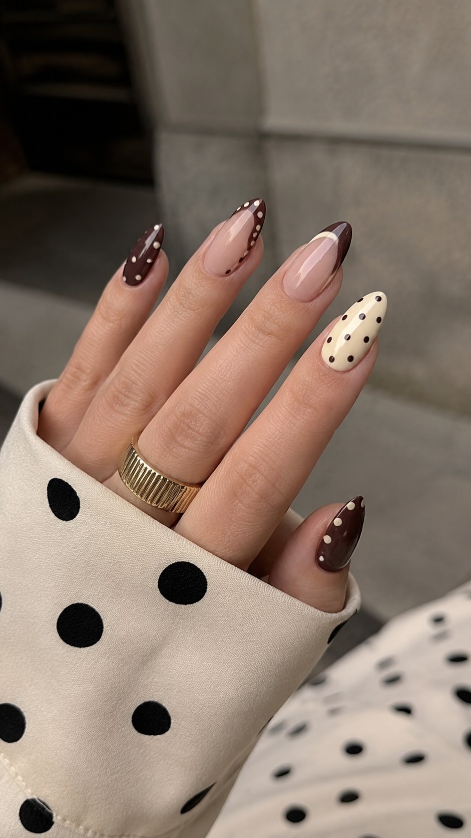 Mixed neutral polka dot nail art with crisp white dots on burgundy and cream