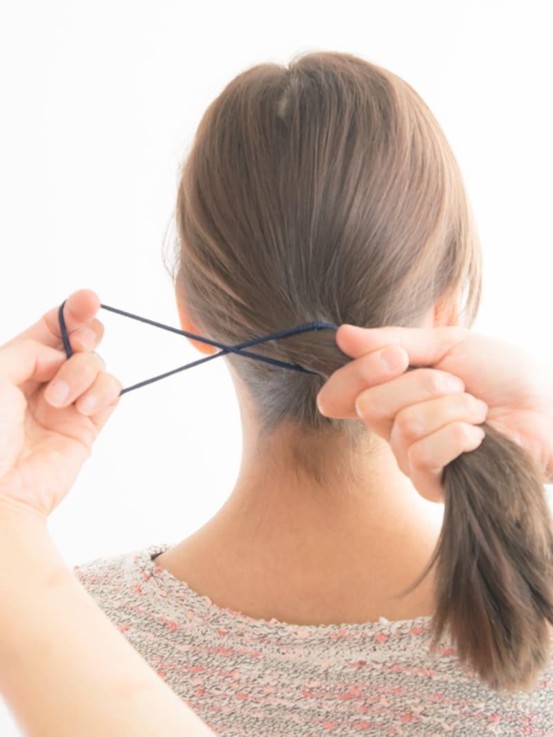 Crossed hair ties securing slippery ponytail