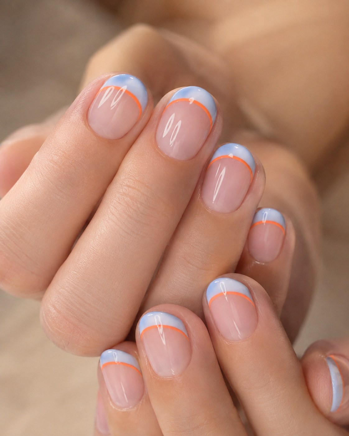 Short summer nails with a modern double-line french tip in soft blue and orange over a nude base