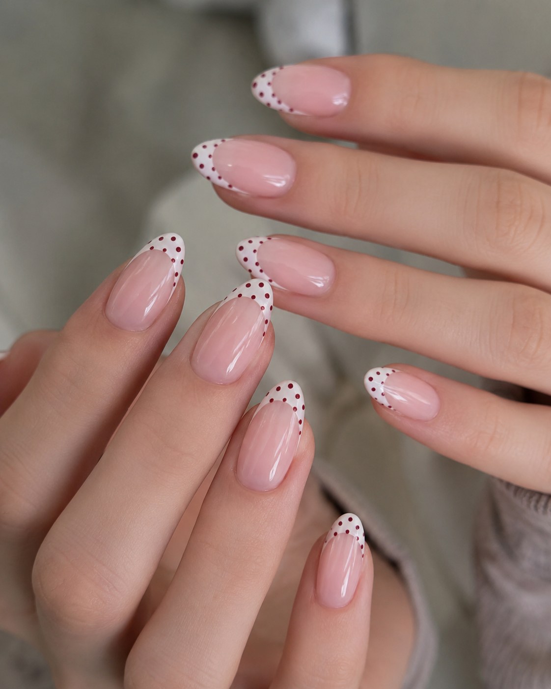 Short summer nails styled with a delicate white french tip and warm reddish-brown dot detailing